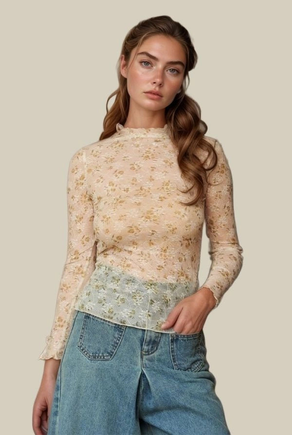 Woman wearing a floral long-sleeve top and blue jeans on a beige background
