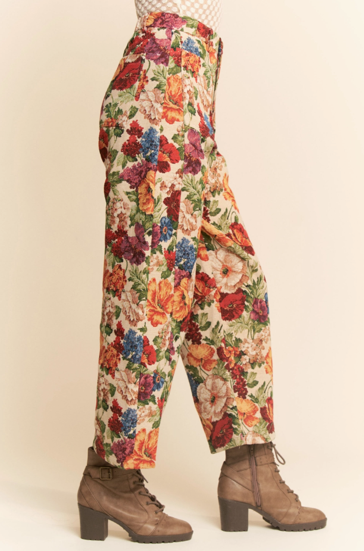 Colorful floral pants worn by a person on a beige background
