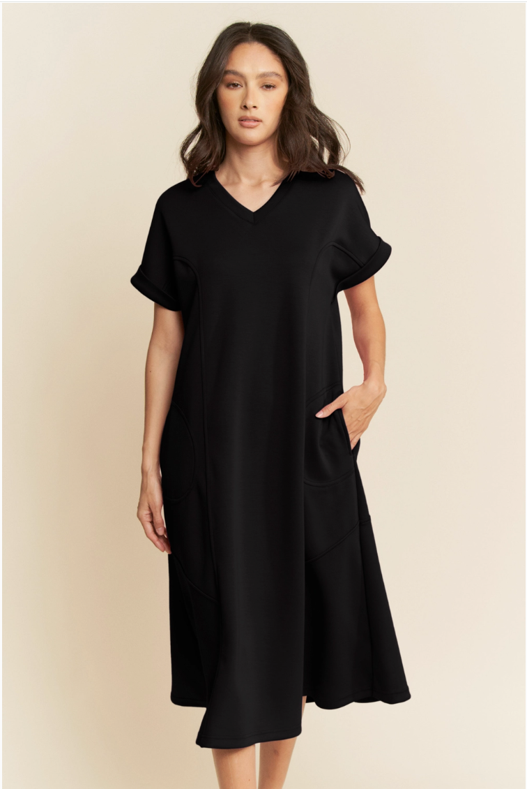 Woman wearing a black dress against a beige background