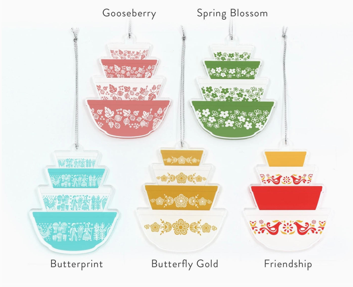 Set of colorful nesting bowls with floral patterns and labels on a white background