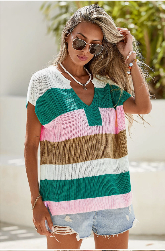 Woman wearing a colorful striped sweater with sunglasses and a blurred background