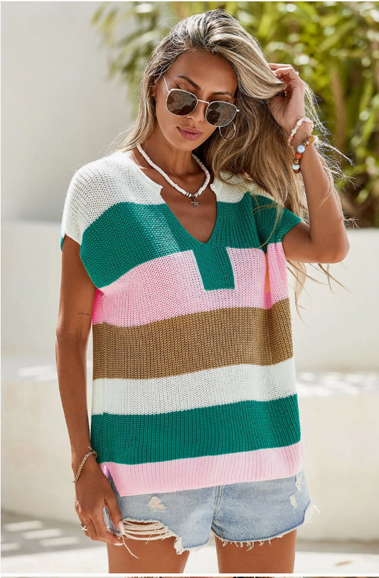 Woman wearing a colorful striped sweater with sunglasses and a blurred background